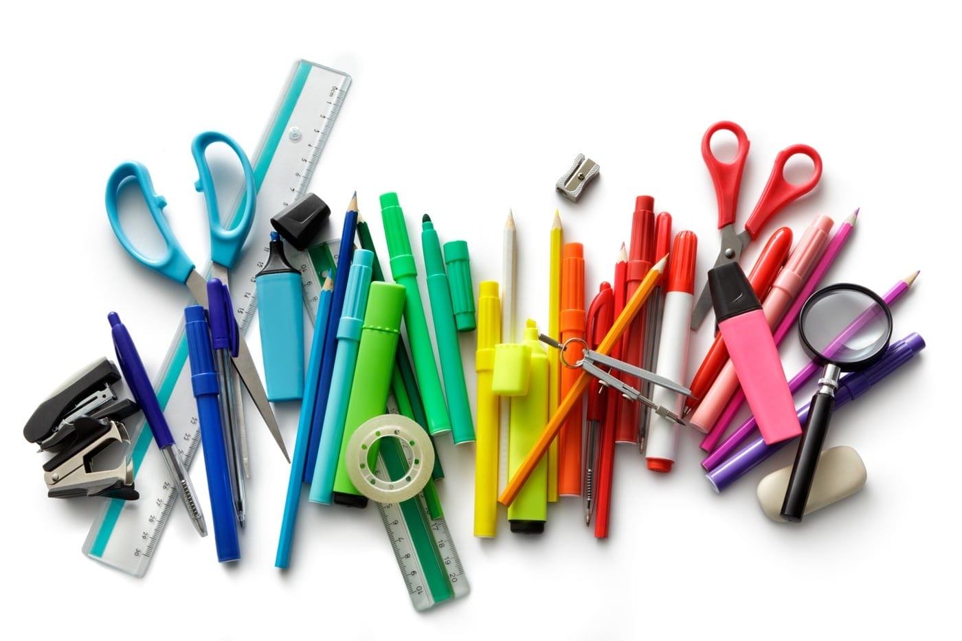 Scattered coloured pens and various stationery items spread across a desk