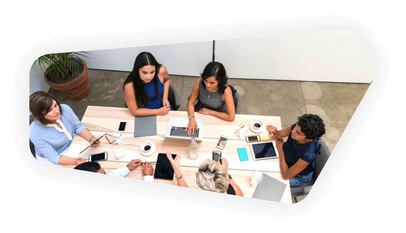 Team engaged in discussion using visible tech tools, illustrating innovation and collaborative planning in codesign processes.