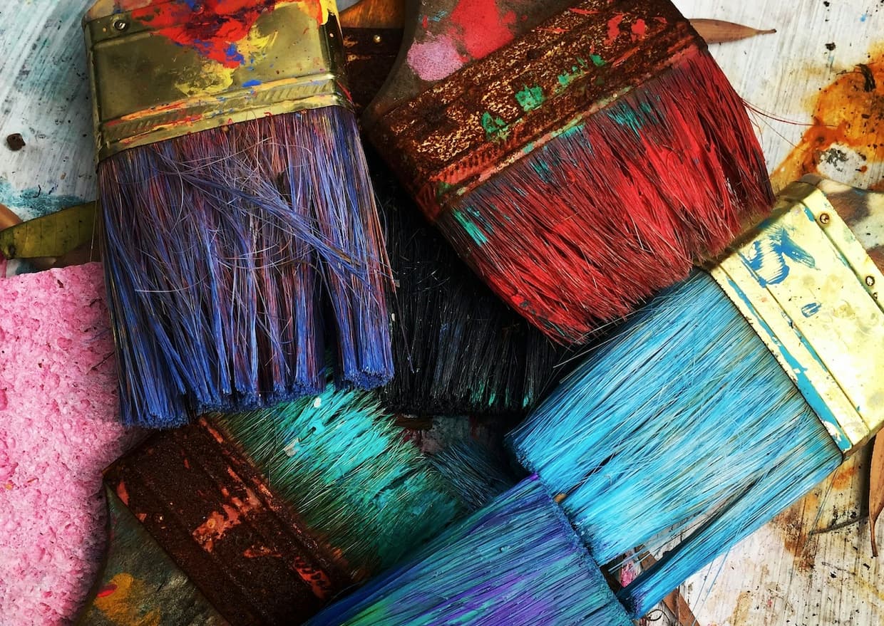 Coloured paint brushes on a craft table